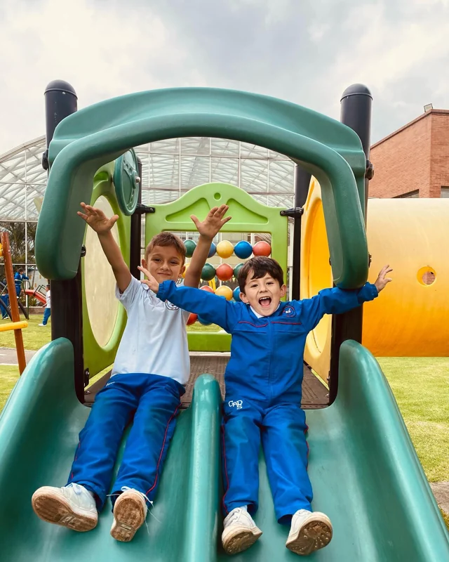 Estudiantes celebrando el mes de los niños en un tobogán